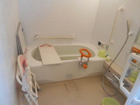 浴槽周りに手すりが付けられシャワーチェアが配置された浴室