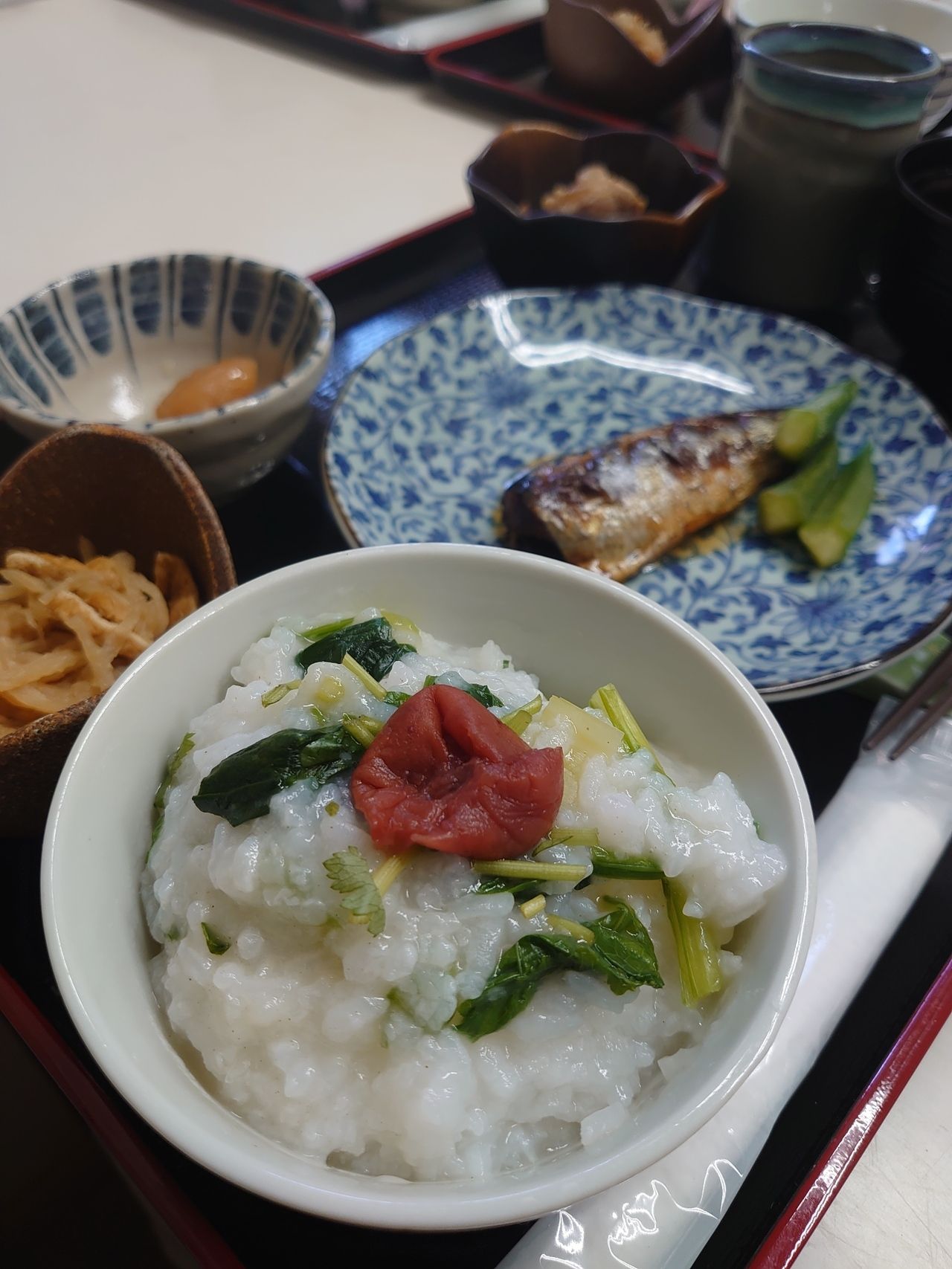 魚料理と、梅干しや葉物をのせたおかゆ