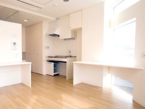 床はフローリング、内装は白で明るいミニキッチンのある居室