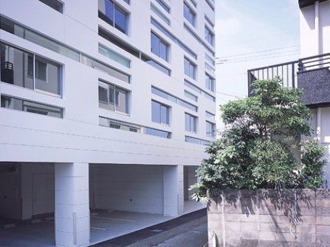 「ウィステリア新上橋」の外観。大通りから、脇に入ってすぐの所に、お洒落なマンションの形をした施設が建っている。