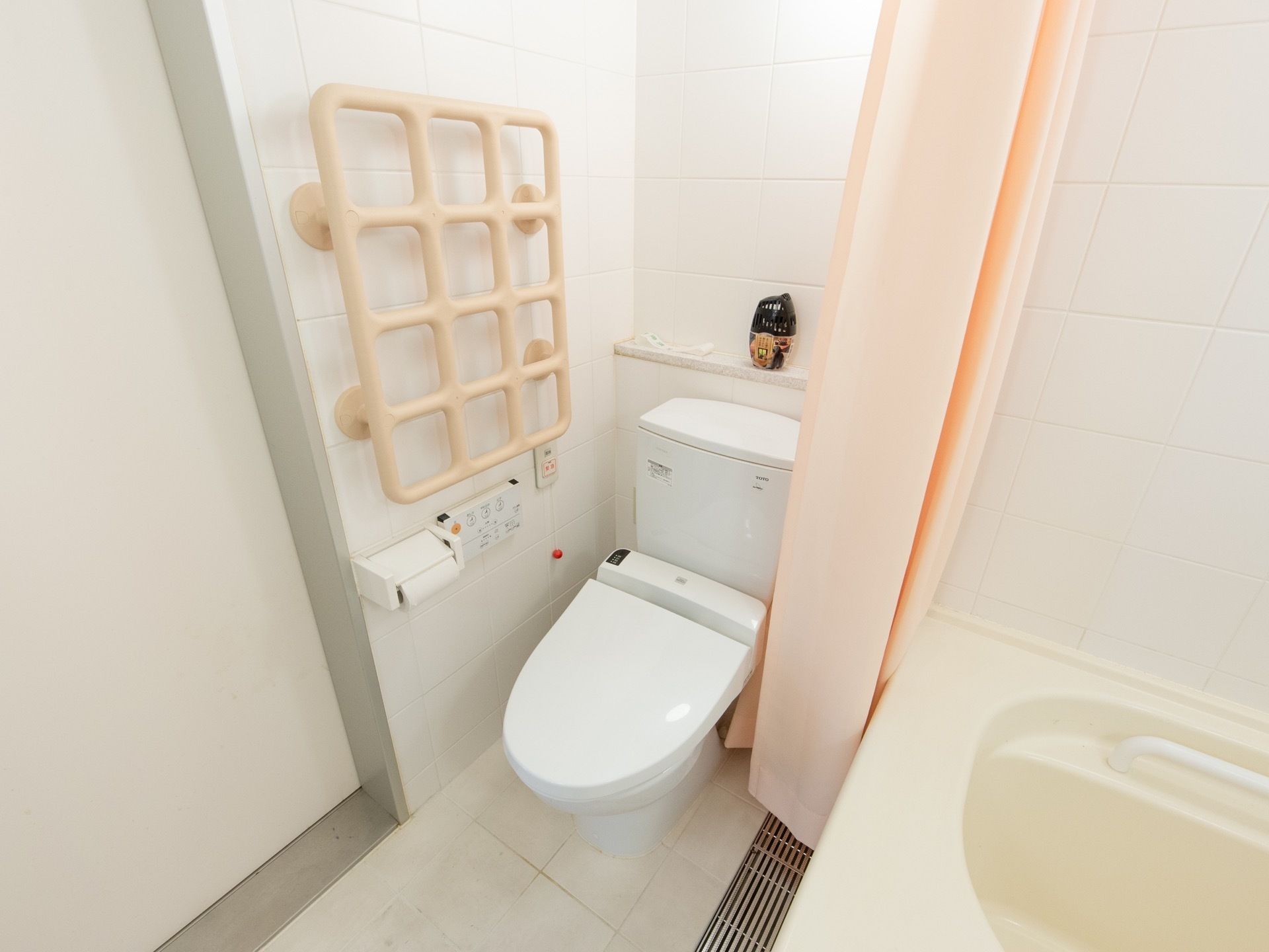 居室備え付けのトイレは、バスルームと共通の個室となっている。壁の手すりは格子状になっていて、いろいろなつかみ方ができる。