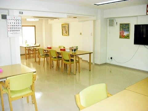 「住宅型有料老人ホーム らくらくホーム大久保」のリビング。テーブルと椅子は、入居者様のに配慮した、使いやすい家具になっている。