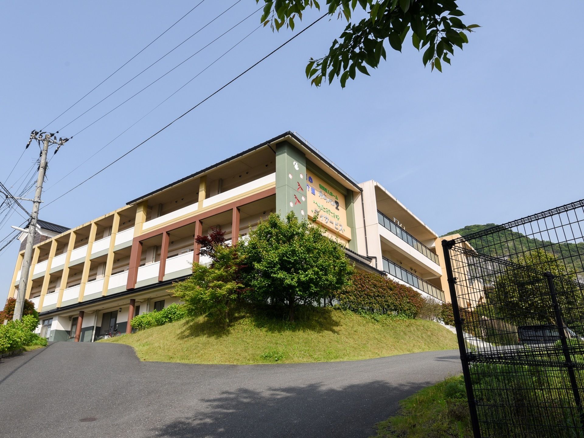 坂を上がった所にそびえ立つ３階建ての施設である。建物の周りには植栽を取り入れ、自然豊かな癒しの空間を設けている。