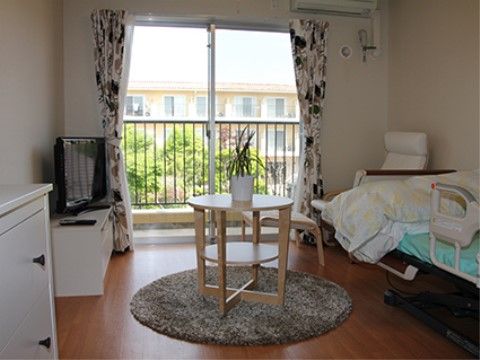 ベッドなどがあり、中央に鉢植えがのっているテーブルがある部屋