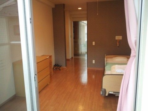 大きな窓のある明るく風通しのよい居室である。介護用ベッドや整理ダンス、非常呼び出しブザーが完備されている。