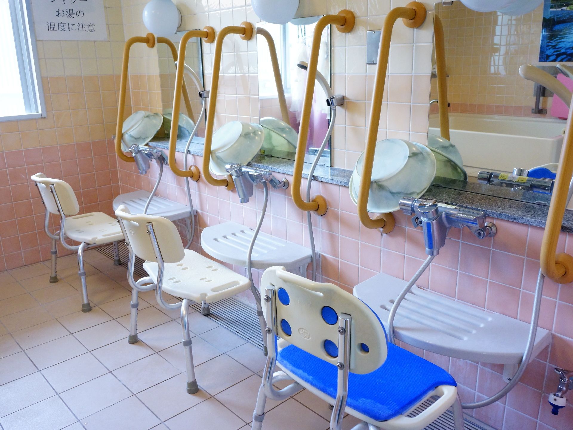 椅子に座り、体が前のめりになって腰に大きな負荷が掛からないよう、桶を置くことのできる台が設置されている。