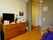 個室の部屋にはベッド、冷蔵庫、チェスト、天板上にテレビなどが置いてある。壁にはコルクボードで写真が貼ってある。