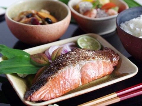 彩りよく美しく盛り付けられた、焼魚を中心とした和風の食事