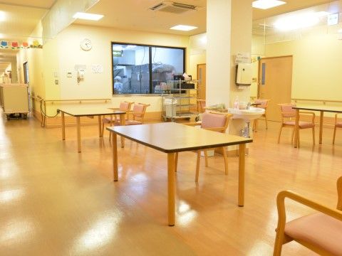 「介護付高齢者住宅 松寿園」のリビング。お食事の場所でも使われるリビングは、常に賑わいながらお食事をしている。
