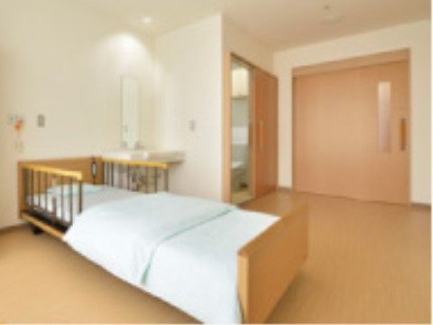 大きなドアがあり、床がフローリングでベッドが中央に置かれている部屋