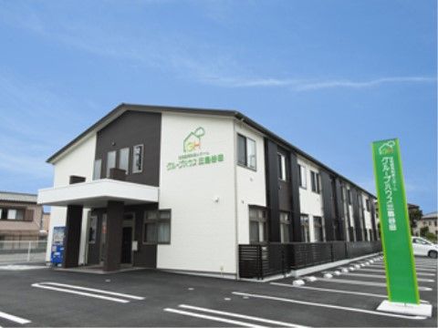 駐車場が隣接している、ツートンカラーの外壁の二階建ての建物
