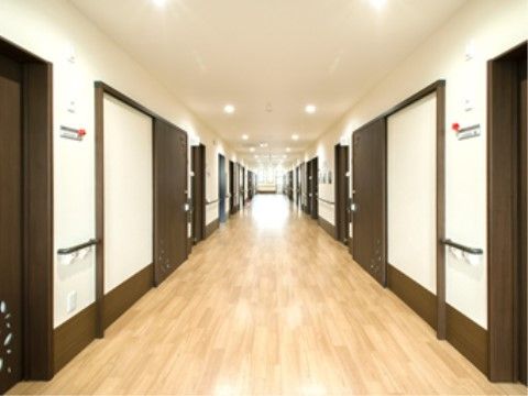 廊下の天井には、丸いライトが２列に配置されており、廊下の両側にある各部屋のドア前を明るく照らしている。