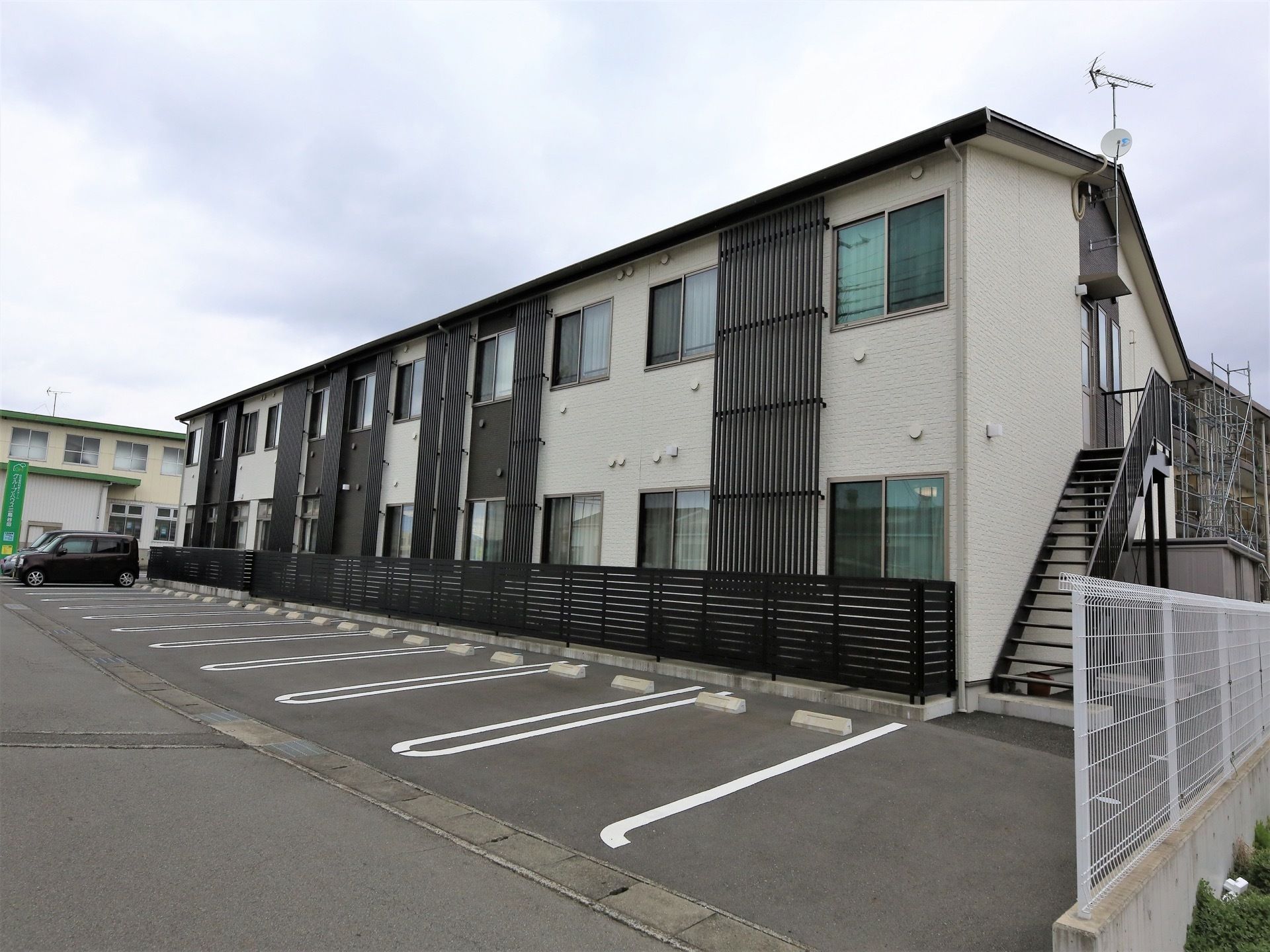施設は２階建てアパートのような建物である。外階段が設置されており、建物裏に駐車スペースが設けられている。