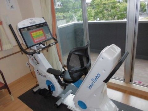 窓の外に緑が見える部屋に置かれたトレーニング用の器具