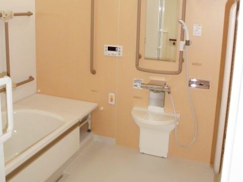暖かい色合いのタイルが貼られた浴室は手すりも設置されており、介助が必要な入居者様も安心して入浴することができる。