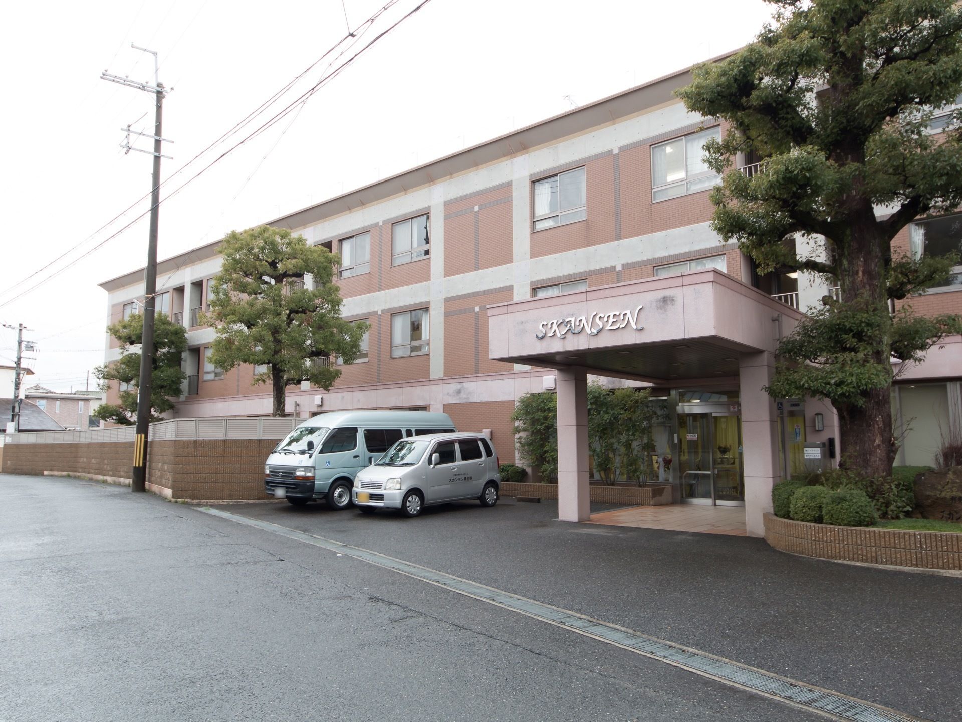 ピンク色の３階建の建物である。玄関の前には大きな車寄せがあるので、車を玄関のすぐ側で停めることができる。