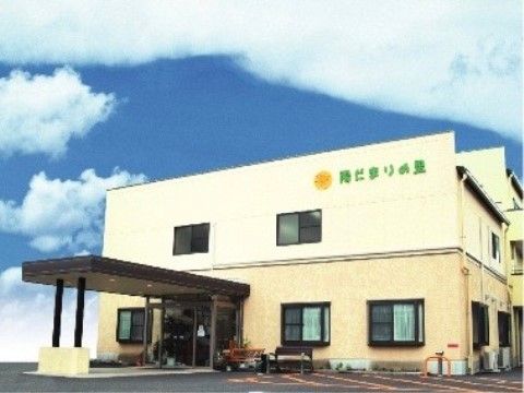大きな雨よけの屋根がついている、クリーム色の二階建ての建物