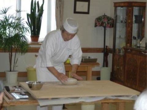 施設内にて食のイベントとして蕎麦打ちをしている職人の写真