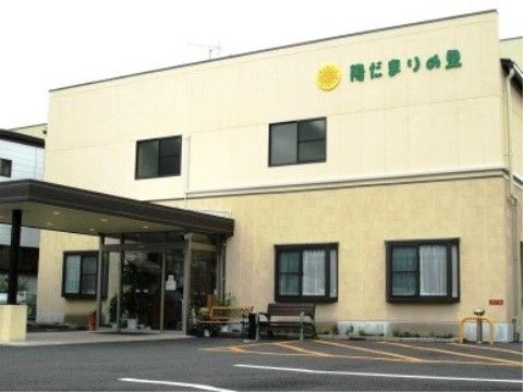 「介護付き有料老人ホーム 陽だまりの里」の外観。ライトイエローの明る施設が、目印になっている。
