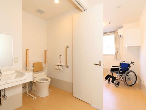 扉が大きく開きスペースにゆとりがある居室内に設置された洋式トイレ