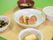 木のトレーの上にご飯、汁物、おかずが3品のっている。食べやすい大きさになっており、中央のメイン料理は見た目も美しく盛り付けされている。