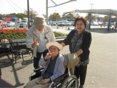 暖かな日差しの中で外出イベントを楽しむ利用者様方の写真