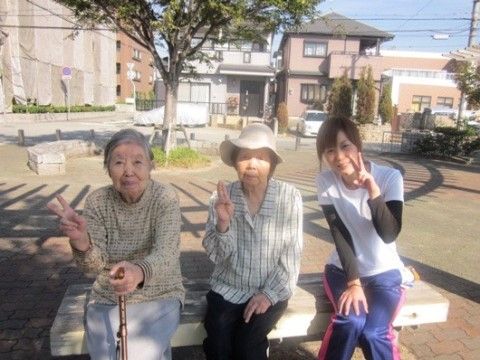 ベンチに座っている高齢女性と女性スタッフ