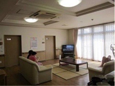 テレビとソファーが設置された共有スペースでくつろぐ入居者さま