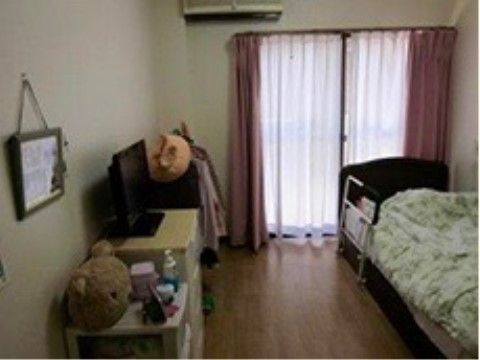 テレビやベッド、収納家具を配置した居室
