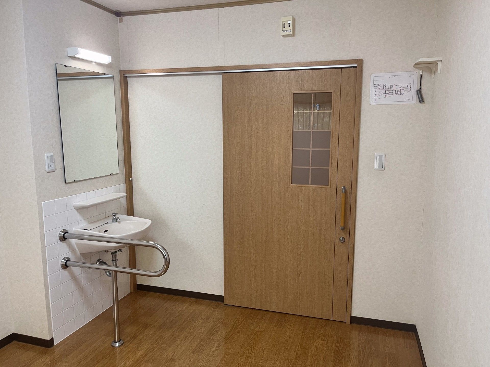 手すり付き洗面所と木製ドア