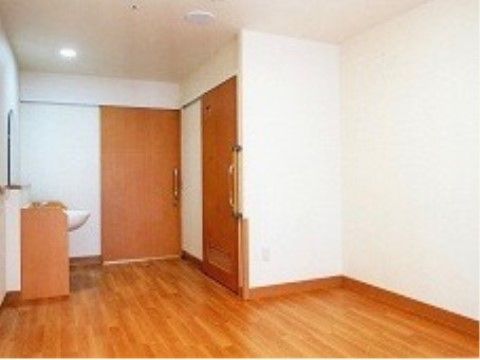 トイレ、洗面台付きの木目の床で広々とした居室スペース