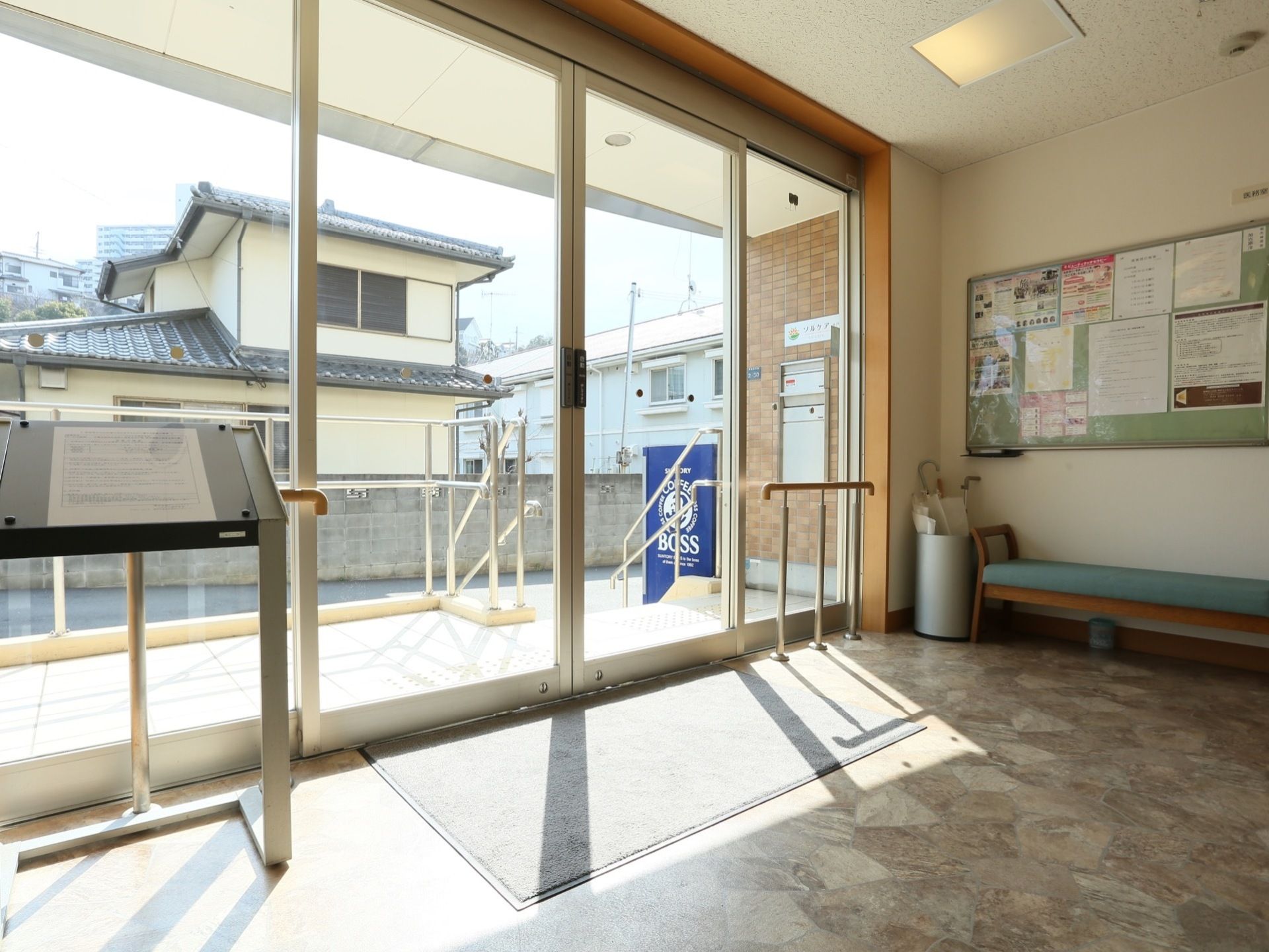 玄関内は段差のない構造で、自動ドアの左右に手すりが設置されている。壁際には長椅子が置かれており、上部には掲示板がある。