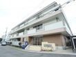白と茶色を基調とした３階建の建物である。２階以上にはベランダが備わっている。玄関前に自動販売機が置かれている。