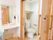 大きめの取っ手がついたスライド式のドアの個室トイレで、花柄のデザインのお揃いの便座カバーとマットが取りつけられている。