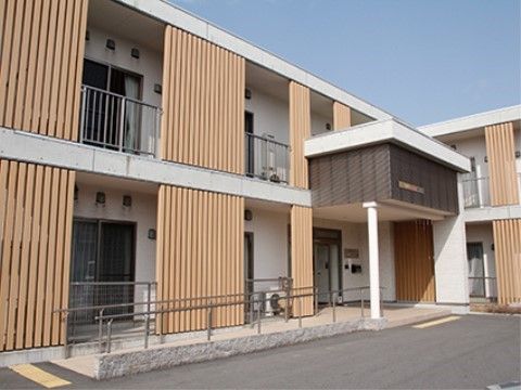 薄い茶色をベースにしたモダンで優しい雰囲気のある2階建て施設の外観