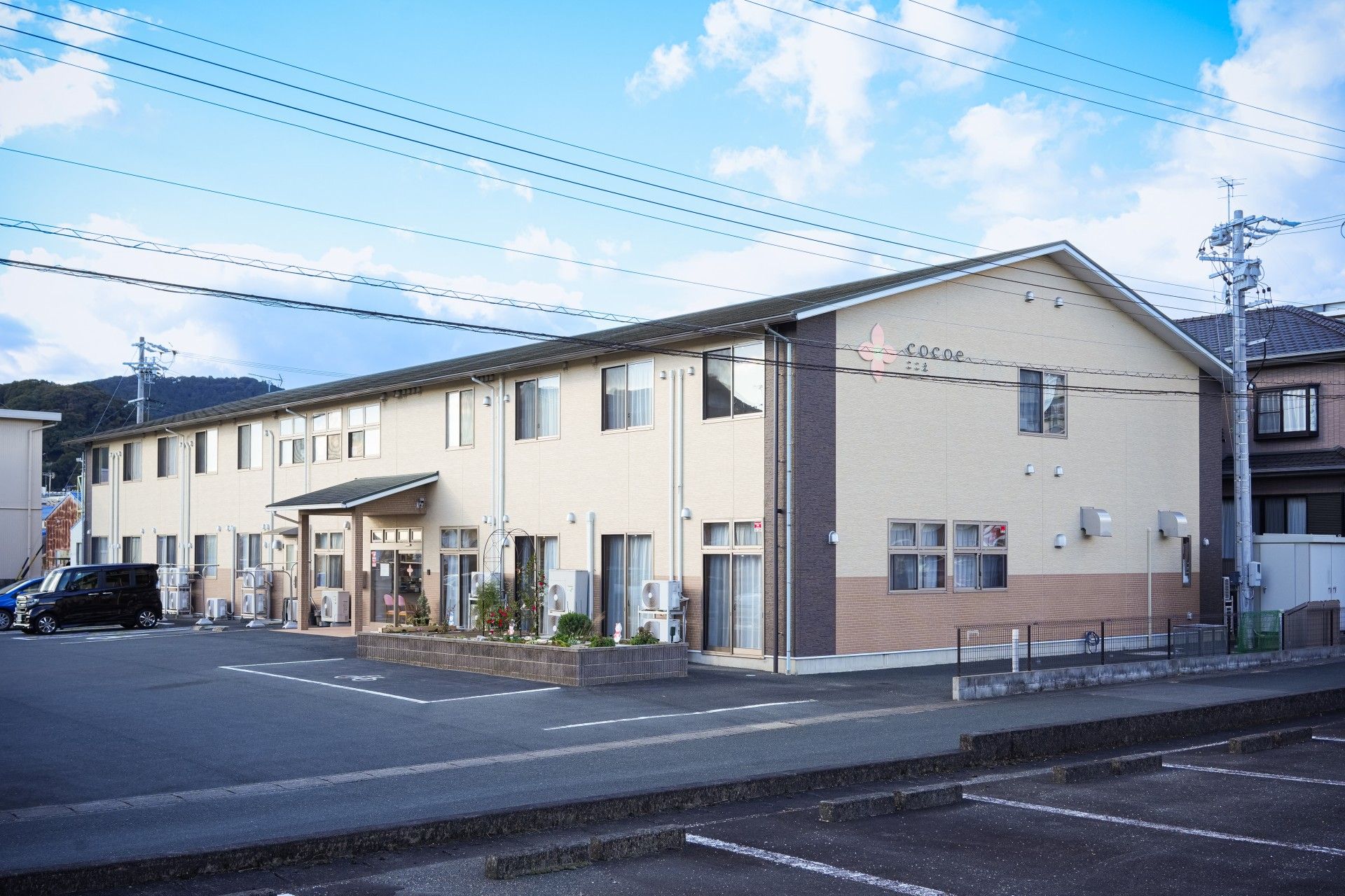２階建ての大規模な建物である。敷地は広く、駐車スペースは車椅子専用と一般、バイクで３分割されている。