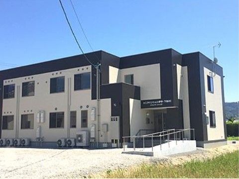 施設は白色、黒色の2色からなっており、玄関入口には白色の文字で施設名が書かれている。手すり付きのスロープがある。