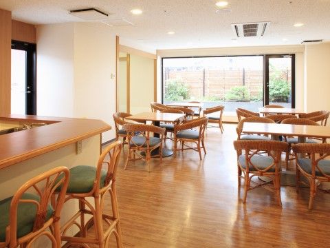 木目調のフローリングにダイニングテーブルセットが設置されている。手前にはカウンターが設けられ、好みの席で食事ができる。