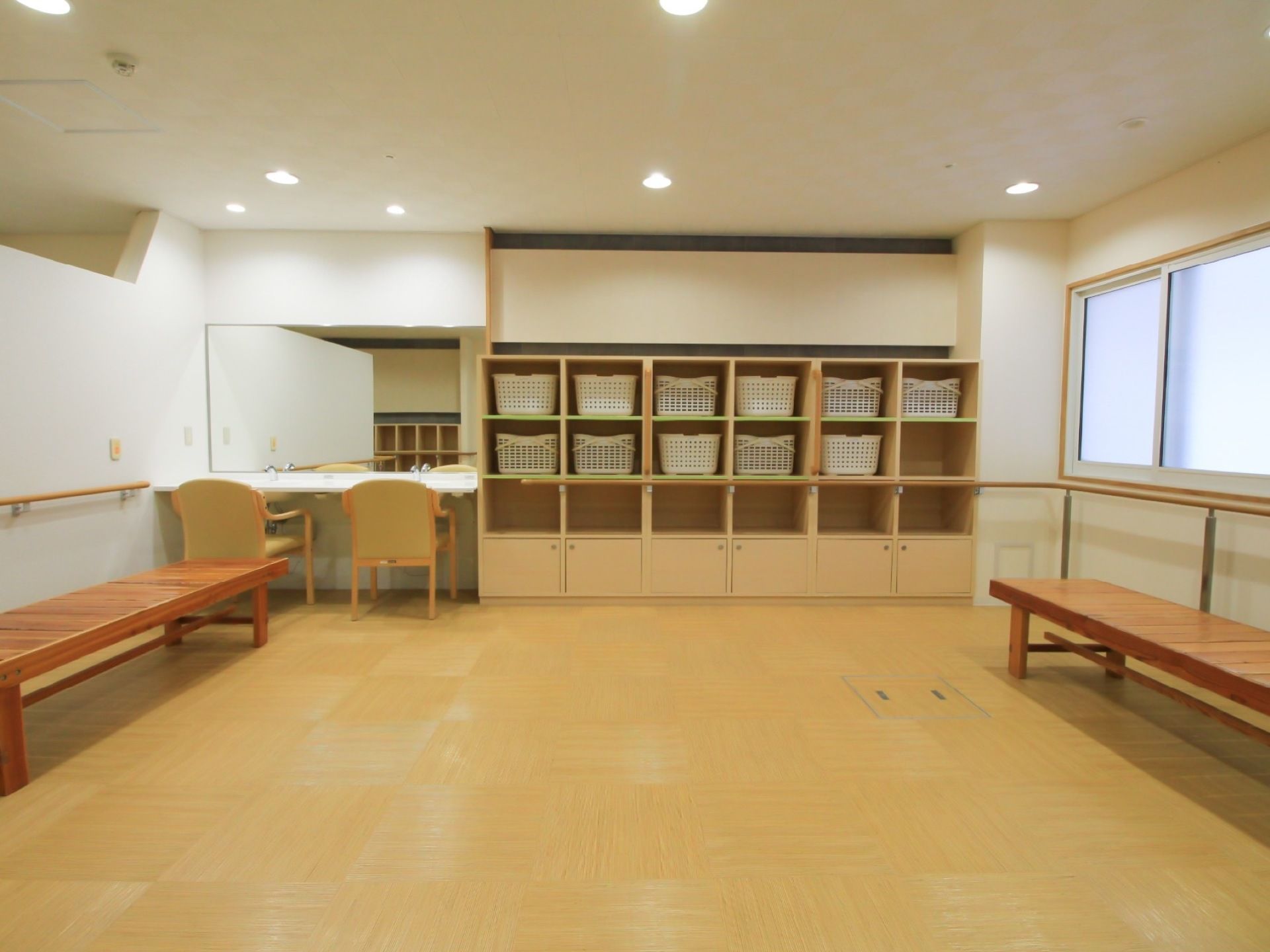 脱衣室の広い室内には、手すりのそばにベンチが置かれ、ゆっくり安心してご利用いただける。脱衣かごも大きなものをご用意。