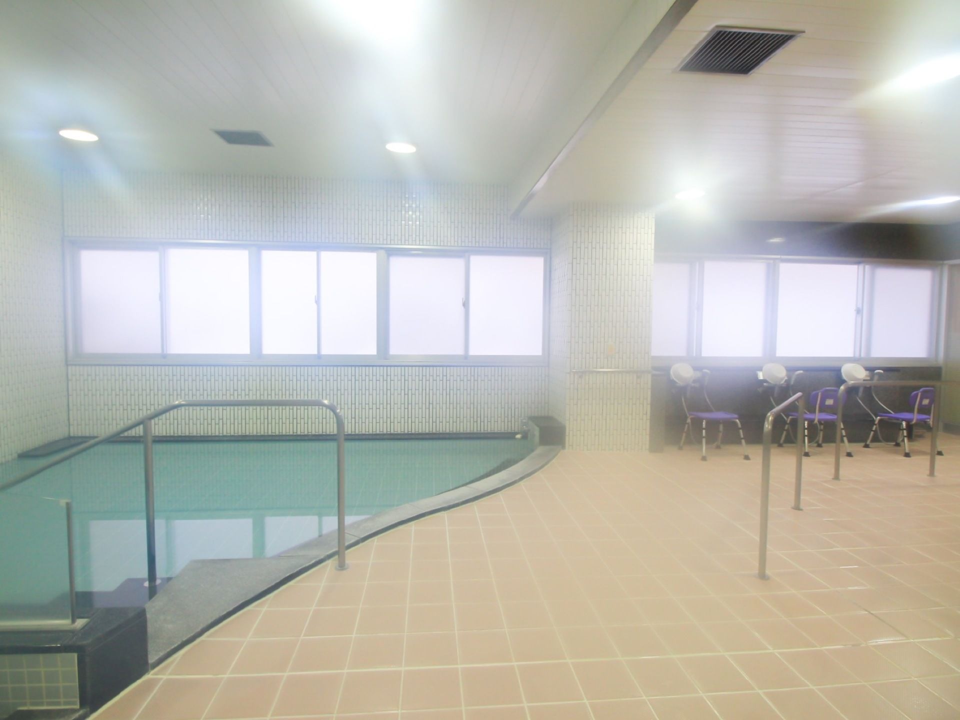 広い空間の浴室の洗い場にも手すりを設け、安全にご利用いただけるようになっている。座高の高い椅子に合わせ、シャワーも高めに設置されている。