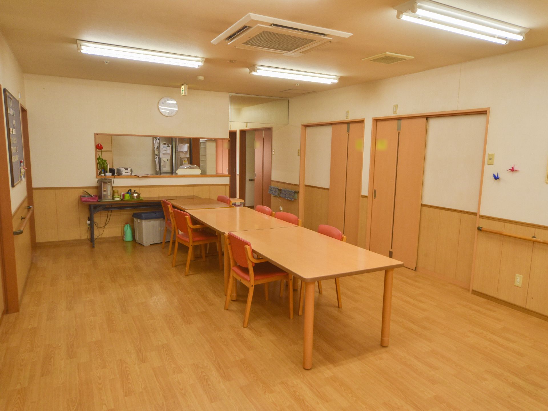 壁沿いには手すりが設置してあり、ドアも見える場所に、テーブルが置かれている。またキッチンカウンターもある。