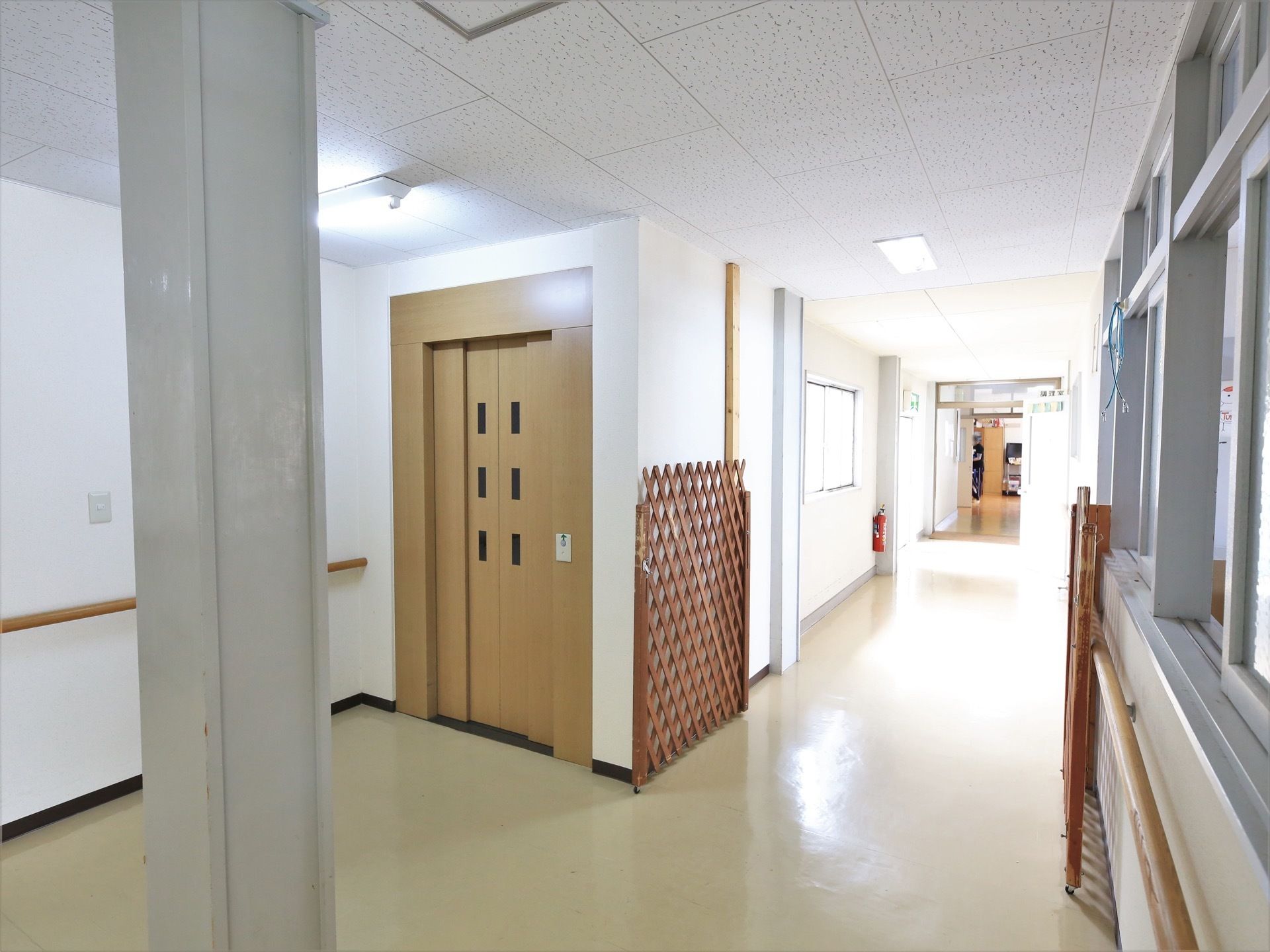 通路の一角にエレベーターの扉がある。居住空間と、調理室や下処理室がある空間との間に、簡易的な扉が設置されている。