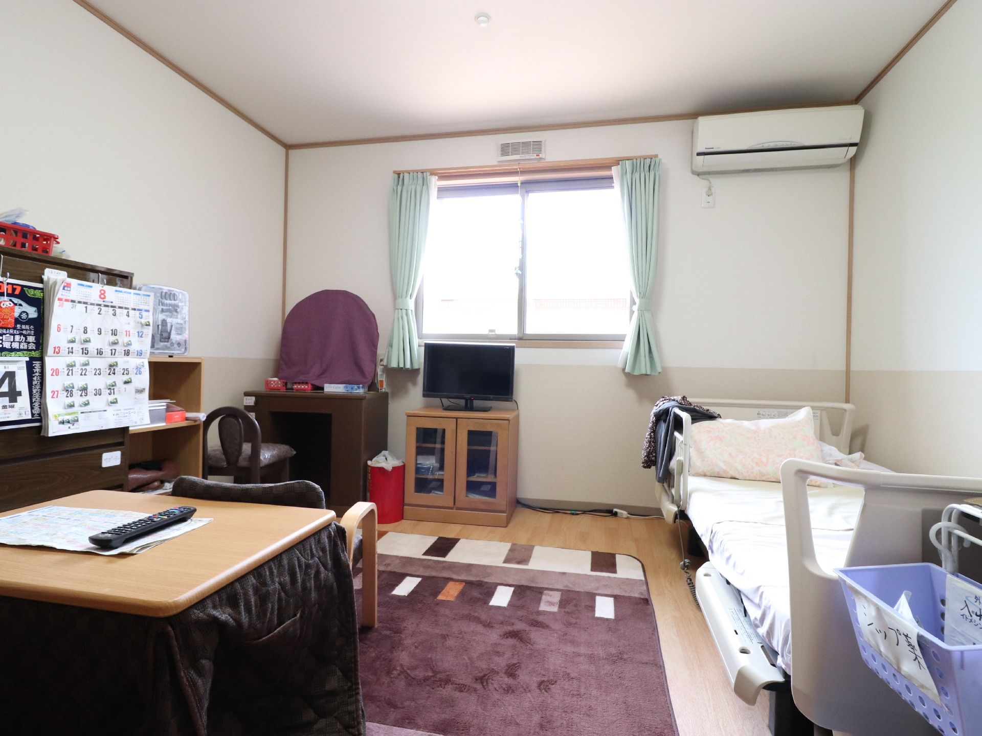 施設の居室は、一般住宅の私室のような部屋になっている。室内にはベッドとテレビ、こたつなどが配置されてある。床にはカーペットが敷かれてある。