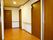 共同で利用する男女兼用のトイレが廊下の端に設置してある。居室前の廊下で、壁には手すりが設置してある。非常口の場を示す矢印が貼ってある。