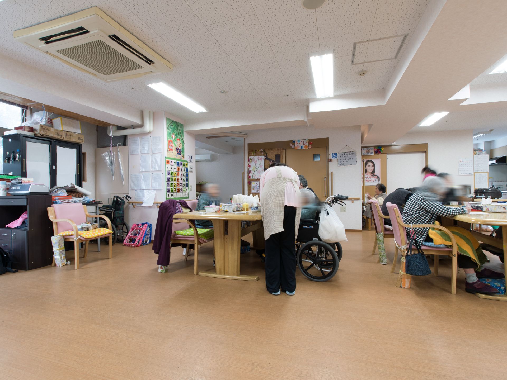 サポートを受けながら食事をする車いすの方や書き物をしている女性など自由な時間を過ごす共有スペース
