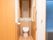 洋式のウォシュレット付きのトイレは、両側の壁に手すりが取り付けられている。洗面台の上に観音扉の収納棚がある。