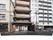 施設建物は片側と背後にマンションが隣接しており、通りに面して建っている。1階の正面にふたのあるスチール素材のゴミ置場が設置されている。