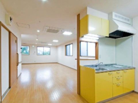 黄色い戸棚のキッチンが付いた広々としたワンルームタイプの居室
