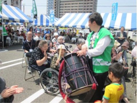 駐車場がイベント会場、太鼓を叩いて楽しむ入居者様とご家族