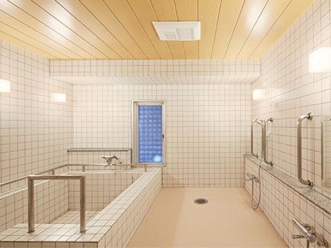 肩まで浸かれる深めの浴槽と、安全のため随所に手すりを備えた明るい浴室